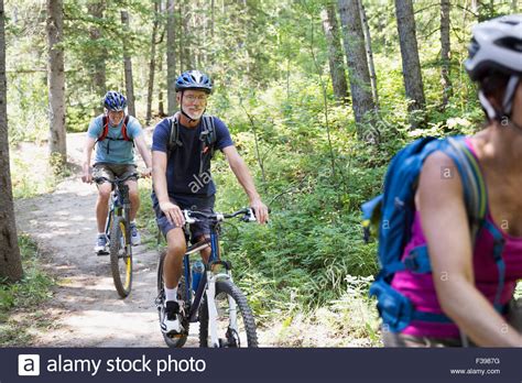 Senior Friends Mountain Biking On Trail In Woods Stock Photo Alamy