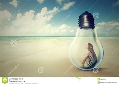 Woman Sitting Inside A Light Bulb On A Beach Looking At The Ocean View
