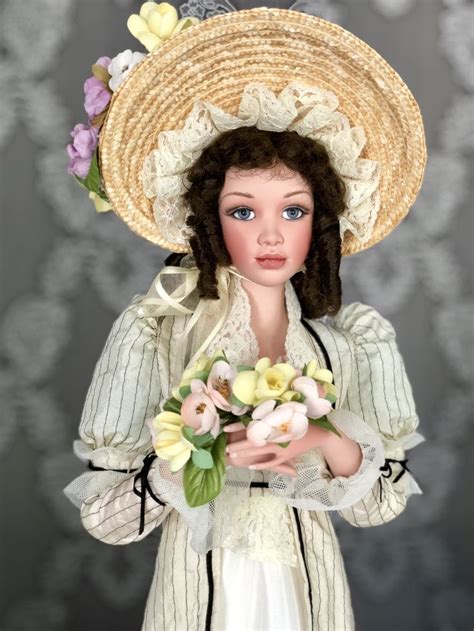 A Doll Wearing A Straw Hat With Flowers In Her Hands And Holding A