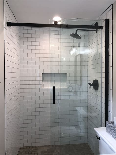 Here are a few important steps to keep in mind: Walk in shower with 3x6 glossy white subway tiles and ...