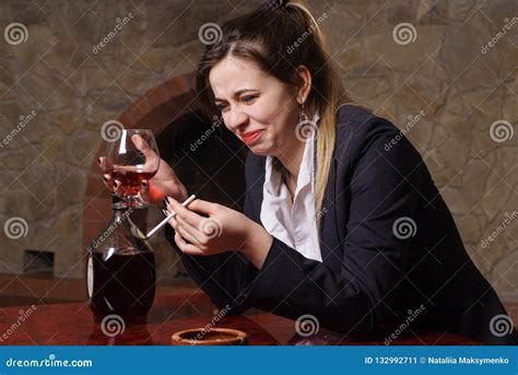 the beautiful girl the drunk girl at a table with a glass and a cigarette stock image image