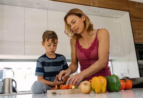 Mother And Son Cooking Together In Kitchen Stock Photo