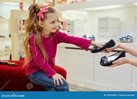 Kleines Mädchen Nimmt Paare Schuhe Von Den Händen Des Verkäufers Stockbild Bild Von Bogen