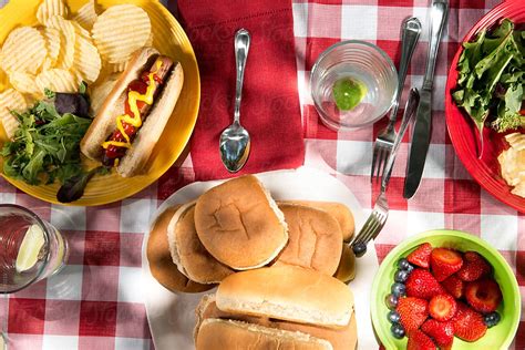 Start with plates, followed by side dishes, main dish, vegetables, salads, breads, and relishes. Picnic Table Setting American Food by Neil Kremer