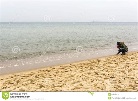 Ragazza Che Raccoglie Le Coperture Sulla Spiaggia Immagine Stock Editoriale Immagine Di Donna