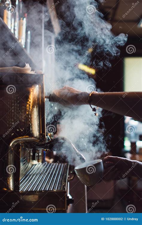 Barista Using Tamper To Press Ground Coffee Into Portafilter In Cafe