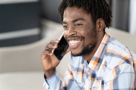 Young African American Man Talking On The Phone Holding Smartphone In