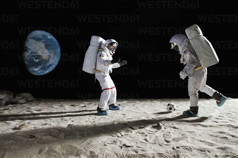 Two Astronauts Playing Soccer On The Moon Stock Photo