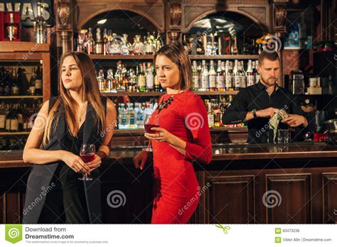 Two Female Friends Are In The Bar For A Drink And Talk The Woman With