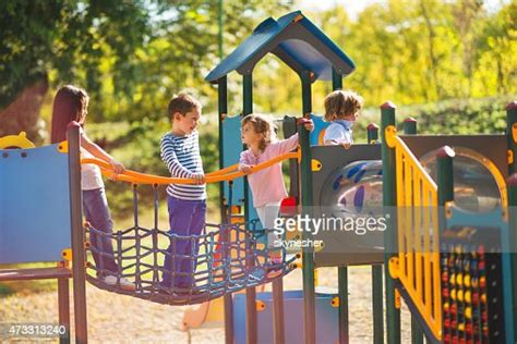 Enfants Jouant Dans Le Parc Au Terrain De Jeux Et De La Communication