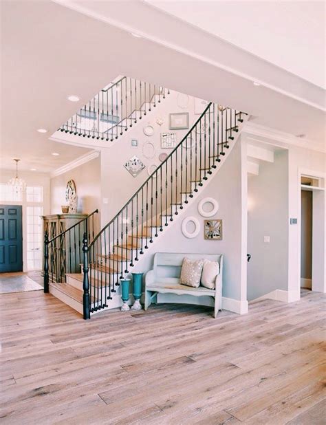 Light Wood Floors And Black Iron Staircase With Light Grey