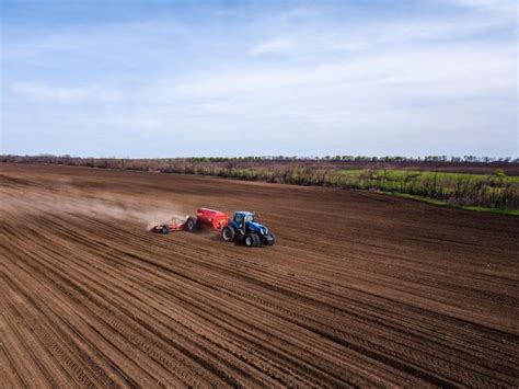 Premium Photo Tractor Cultivating Fields Under Blue Sky Photo From Drone