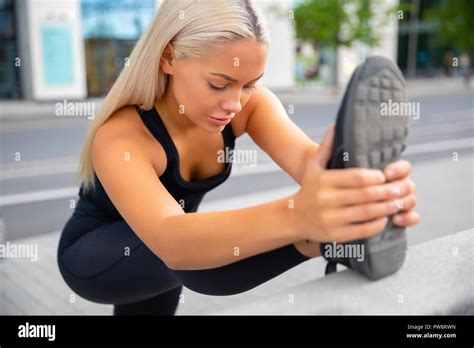 Beautiful Urban Female Stretching Her Leg Before Exercise Stock Photo