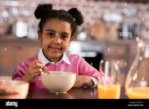 Portrait Of Smiling Little Girl Having Breakfast At Home Stock Photo