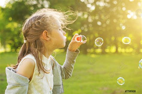 Little Girl Blowing Soap Bubbles In The Park Stock Photo Crushpixel