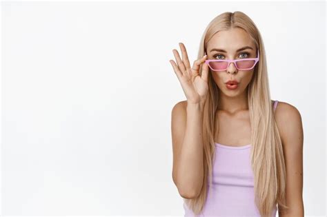 premium photo stylish blond woman looking surprised take off sunglasses and stare amazed