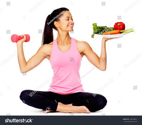 Portrait Of A Healthy Woman With Vegetables And Dumbbells Promoting A
