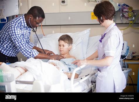 A Young Boy Is Checked By A Doctor And Nurse On A Childrens Hospital