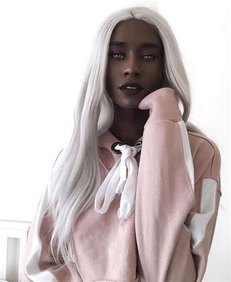 A Mannequin Wearing A Pink Sweater And White Hair
