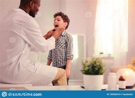 Doctor Examining The Child Having Problems With Throat Stock Photo