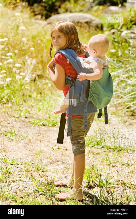 Girl Carrying Baby Sibling On Back Stock Photo Alamy