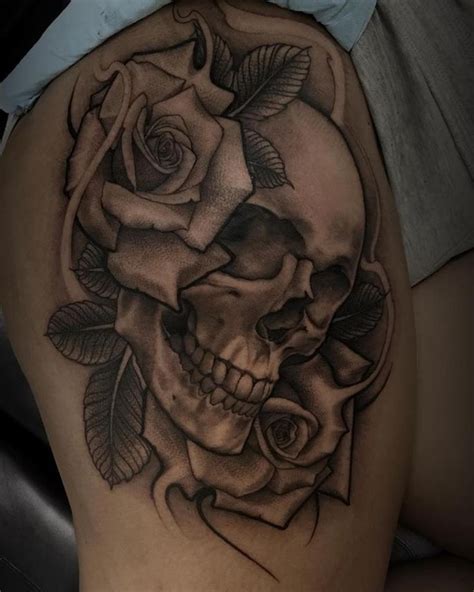 A Womans Thigh With A Skull And Rose Tattoo On It