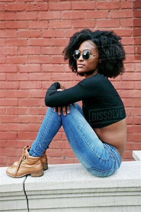 Portrait Of Black Woman Sitting On Ledge Outdoors Stock Photo Dissolve