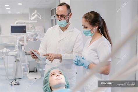 Young Woman Getting Dental Treatment In Clinic Denist And Assistant