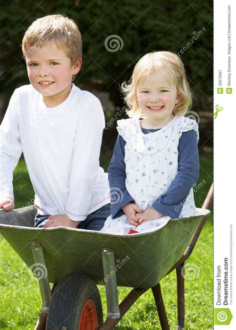Two Children Sitting In Wheelbarrow Stock Image Image Of Summer