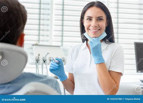 Female Dentist At Procedure Holding Dental Drill In Modern Dental
