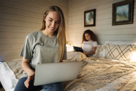 Two Beautiful Women Lying In Bed Holding A Laptop Stock Photo Image
