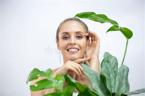 Portrait Of Young And Beautiful Woman With Perfect Smooth Skin In Tropical Leaves Concept Of
