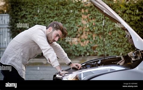 Handsome Young Man Trying To Repair A Car Engine Looking Inside Open