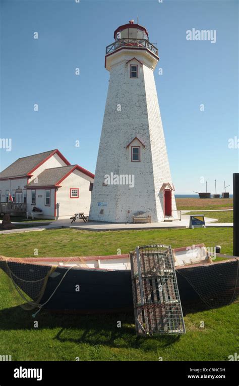 The East Point Lighthouse Sits Behind A Dory And Lobster Trap In Pei