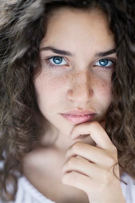 Beautiful Young Woman With Curly Hair Blue Eyes And Freckles Looking In Camera By Maja Topcagic