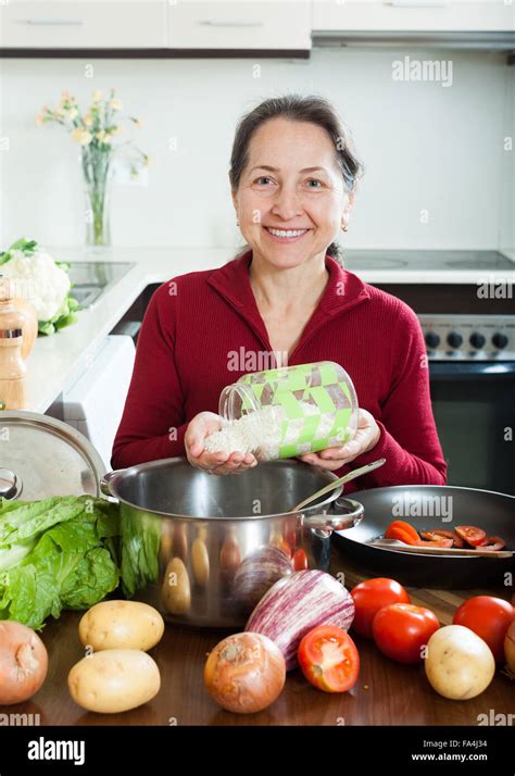 Smiling Mature Woman Cooking Soup With Rice Stock Photo Alamy