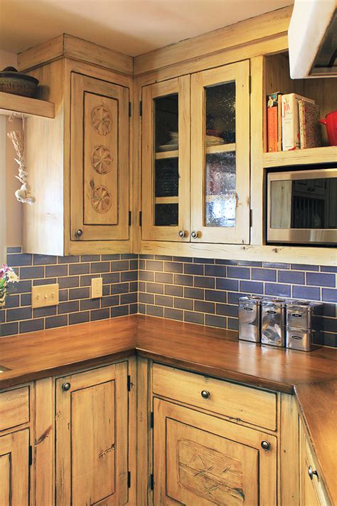 If you're ready to replace your cabinets, consider simply replacing your kitchen cabinet doors and drawer fronts instead. Kitchen Cabinets with Antique Panels - La Puerta Originals