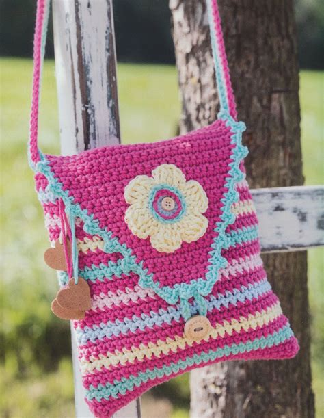 A Crocheted Purse Hanging On A Wooden Fence With A Tree In The Background