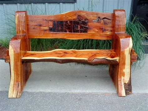 A Wooden Bench Sitting On The Side Of A Sidewalk Next To Grass And