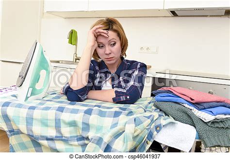 Young Beautiful And Sad Woman Or Busy Housewife Ironing Shirt Lazy At Home Kitchen Using Iron