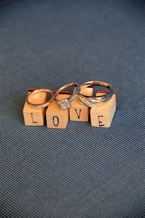 Wedding Rings On Wood Tiles That Spell Out The Word Love Stock Photo