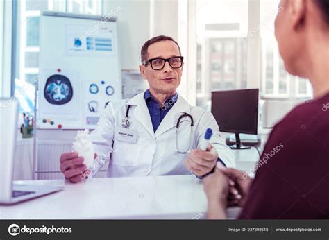Positive Delighted Medical Worker Consulting His Patient Stock Photo By