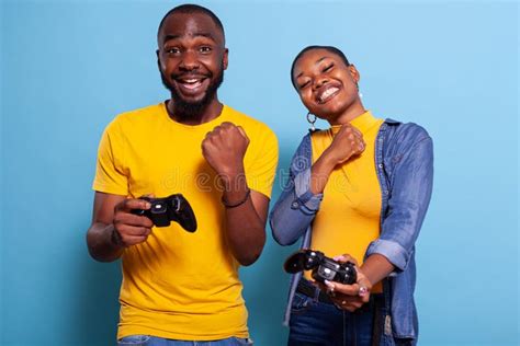 Cheerful Boyfriend And Girlfriend Playing Video Games To Win Stock