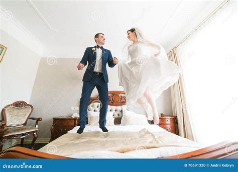 Schöne Glückliche Braut Und Bräutigam Die Auf Das Bett Im Reichen Hotelinnenraum Springt