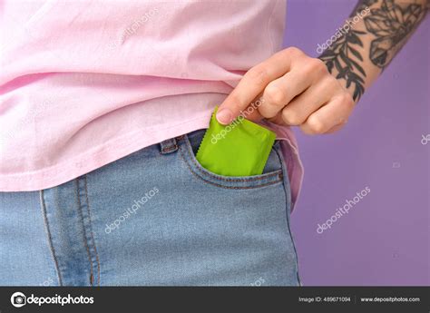 Woman Putting Condom Pocket Jeans Color Background Closeup Stock Photo By Serezniy