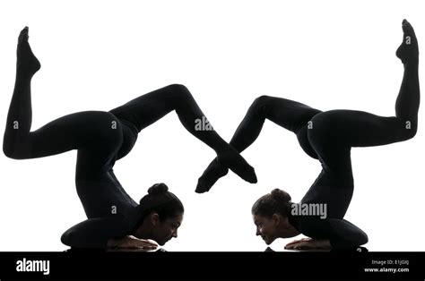 Two Women Contortionist Practicing Gymnastic Yoga In Silhouette On