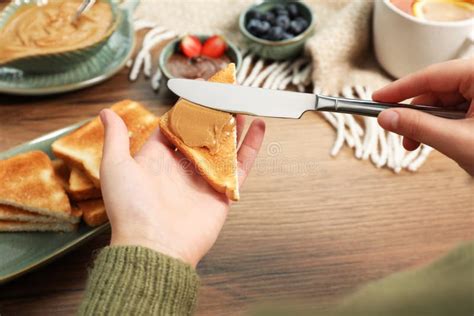 Woman Spreading Peanut Butter Onto Toast At Wooden Table Closeup Stock Photo Image Of Crunchy