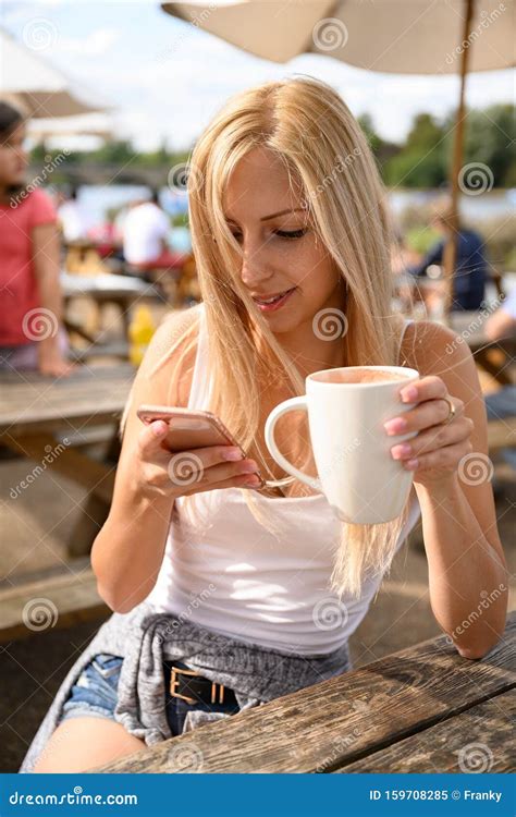 Attractive Blond Girl Having Coffee Latte On The Coffee Bar Terrace In
