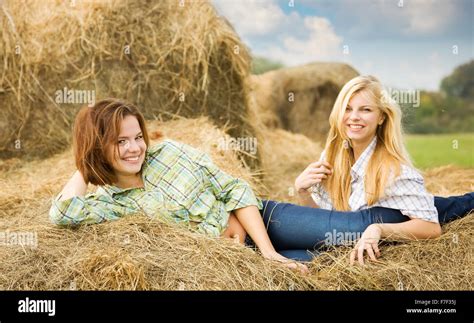 Pretty Girls In Checked Shirts Resting On Hay Bale Stock Photo Alamy