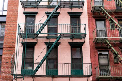 A Pink Brownstone Is Surrounded By Brick Apartments In New York City